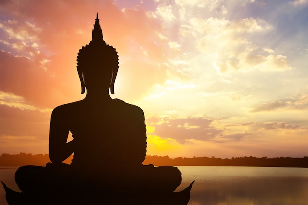 Magha Asanha Visakha Puja Day , Silhouette Buddha on golden sunset.