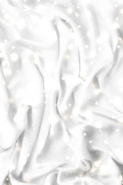 Magic holiday white soft silk flatlay background texture with glowing snow luxury beauty abstract backdrop