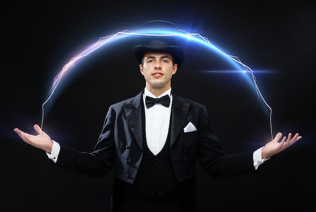 magic, performance, circus, show concept - magician in top hat showing trick