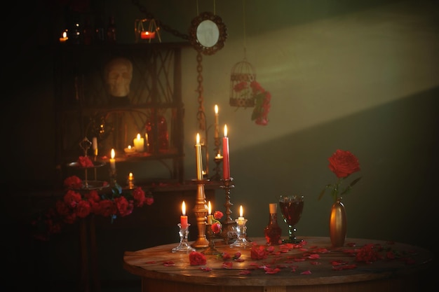 Magic potion with red roses and burning candles in dark room