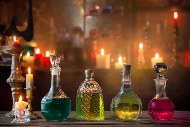 Magic potions in bottles on wooden background