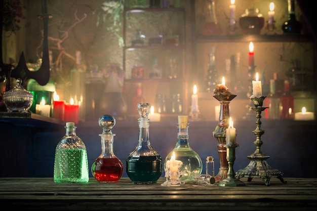 Magic potions in bottles on wooden background