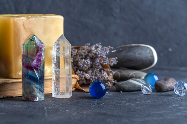 Natura morta magica con cristallo di quarzo fluorite e candela rosa rocce magiche per rituale mistico stregoneria wiccan o pratica spirituale guarigione rituale di meditazione reiki per amore ed equilibrio dei chakra