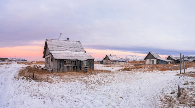 북극의 오래된 마을과 마법의 다채로운 일몰. Teriberka의 겨울 도시의 전망. 러시아.