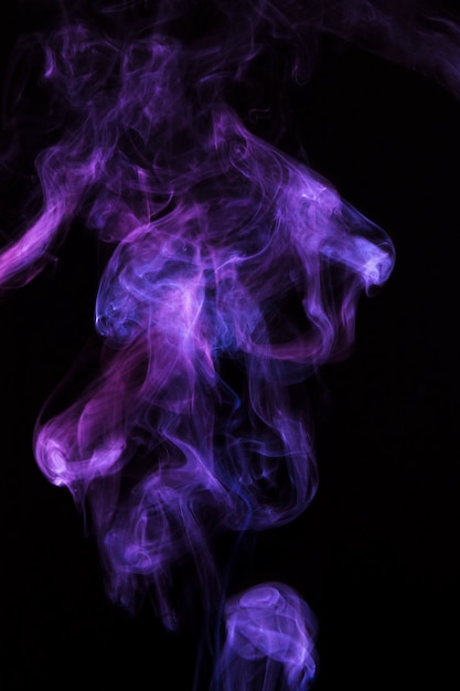 Magical purple smoke spread over black background