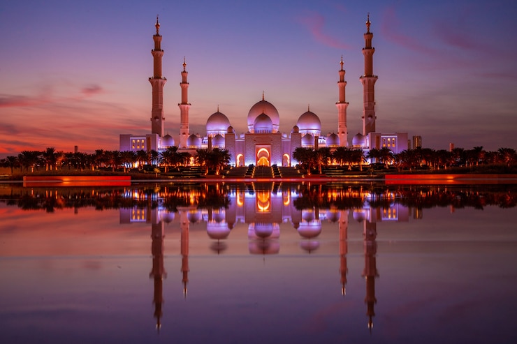 Photo magical purple sunset of the grand mosque in abu dhabi in the evening during sunset. panorama of exterior of sheikh zayed mosquein uae.