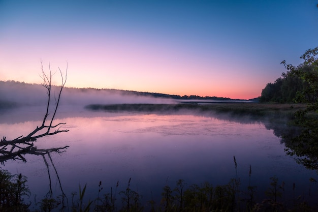 Magical sunrise over lake Misty morning rural landscape wilderness mystical feeling