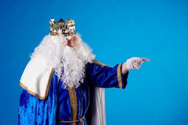 The Magician King pointing to a billboard on a blue background