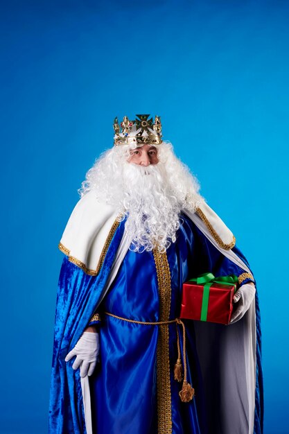 The Magician King with a present on a blue background