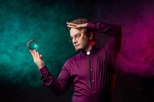 Foto il mago fa uno spettacolo di levitazione della sfera di vetro.