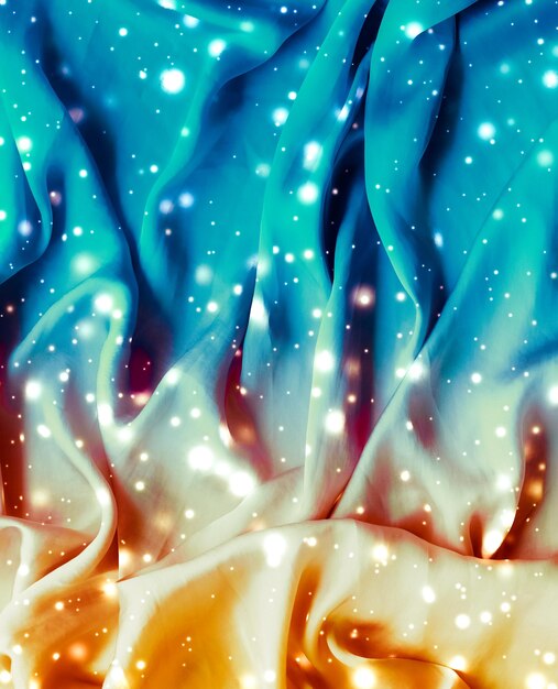 Magische vakantie blauwe en gouden zachte zijde flatlay achtergrondstructuur met gloeiende sneeuw luxe schoonheid abstracte achtergrond
