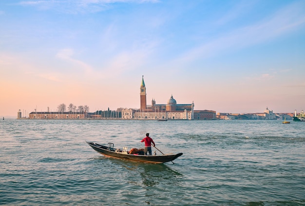 Foto magische zonsopgangkleuren in venetië een gondelconducteur neemt je mee door de stad