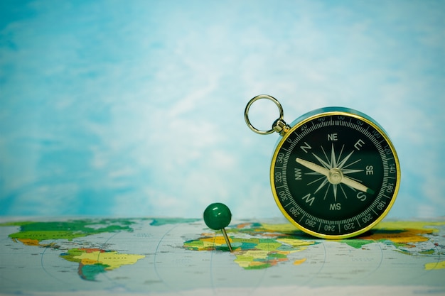 Magnetic compass on world map, concept of travel and destination, macro travel