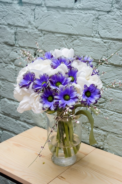 Photo magnificent bouquet with white tulips and a dyed purple chrysanthemum in a transparent vase