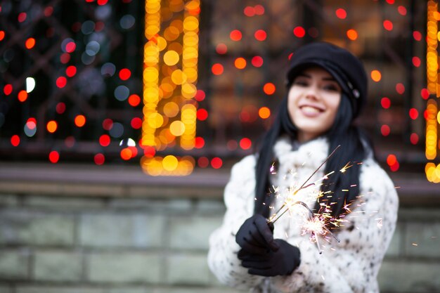 Photo magnificent smiling brunette girl having fun with bengal lights outdoor. space for text