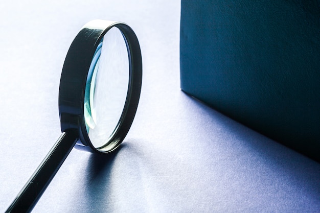 Photo magnifier on blue surface close up