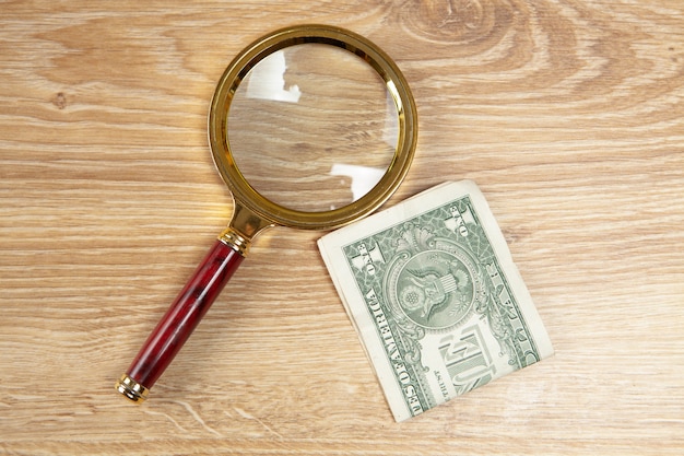 Photo magnifier and dollar bills on the table