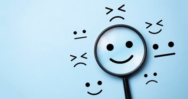 Увеличительное стекло и знаки эмоций. Удовлетворенность клиентов и их оценка после обслуживания или маркетингового исследования.