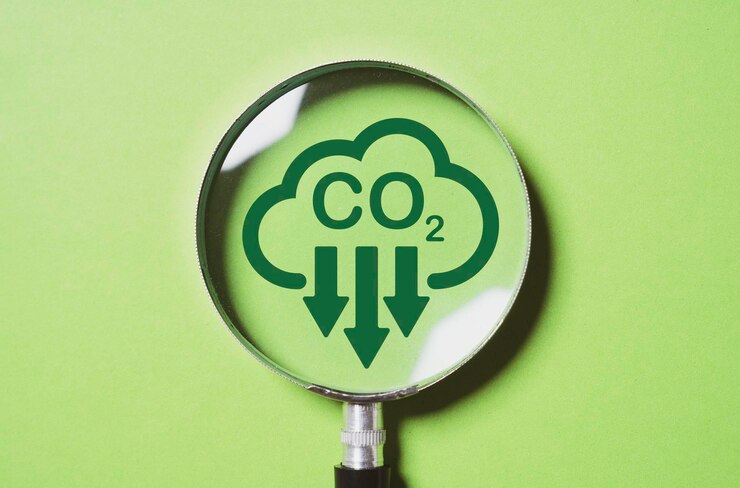 फोटो magnifier glass with co2 reduction on green background for decrease co2 carbon footprint and carbon credit to limit global warming from climate change in kyoto protocol 2050 concept