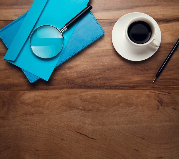 Magnifier on letter and cup of coffee on the table