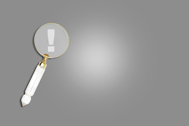 Magnifier magnifying exclamation mark on gray background Alert and precaution concept