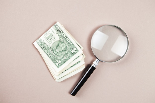 Magnifier and money on white surface