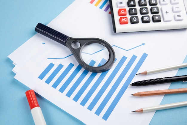 Magnifier, statistics and calculator on the blue table