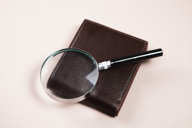 Magnifier and wallet on wooden table