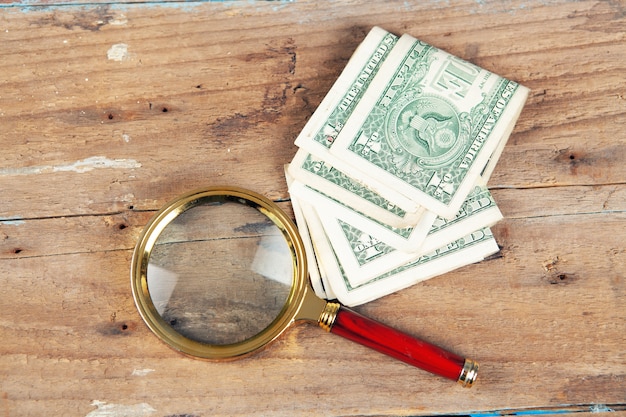 A magnifying glass and a banknote on the table