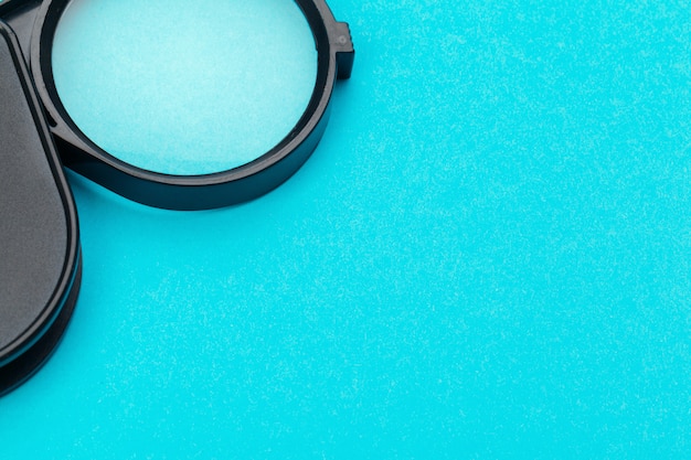 Magnifying glass on blue pastel