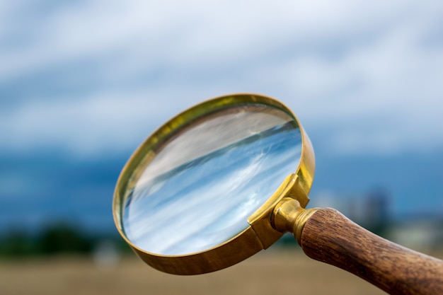 magnifying glass on blue sky magnifying glass over blue sky magnifying glass against blue sky