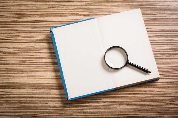 Magnifying glass and book o the wooden 