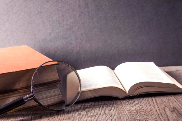 magnifying glass and book on the wooden background