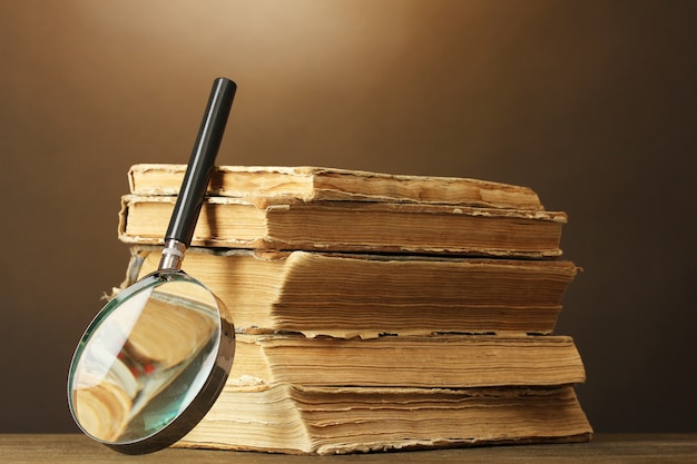 Magnifying glass and books on brown