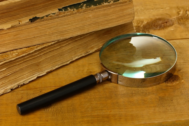 Magnifying glass and books on table