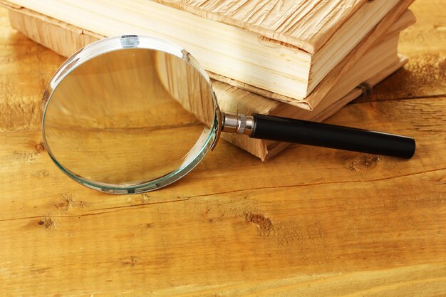 Magnifying glass and books on table