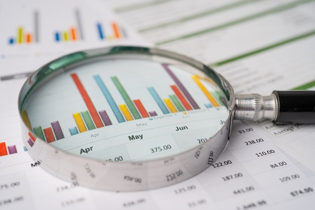 Magnifying glass on charts graphs paper. financial development,
banking account, statistics, investment analytic research data
economy, stock exchange trading, business office company meeting
concept.