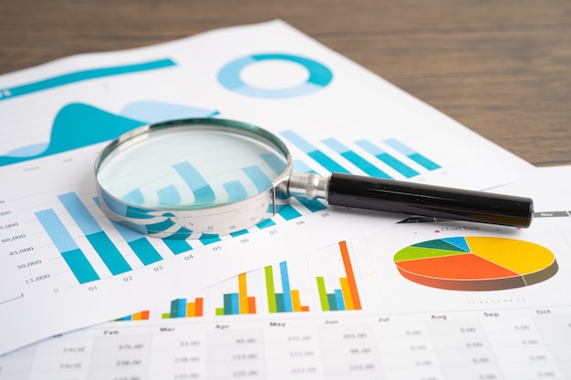 Magnifying glass on charts graphs paper. financial development,
banking account, statistics, investment analytic research data
economy, stock exchange trading, business office company meeting
concept.