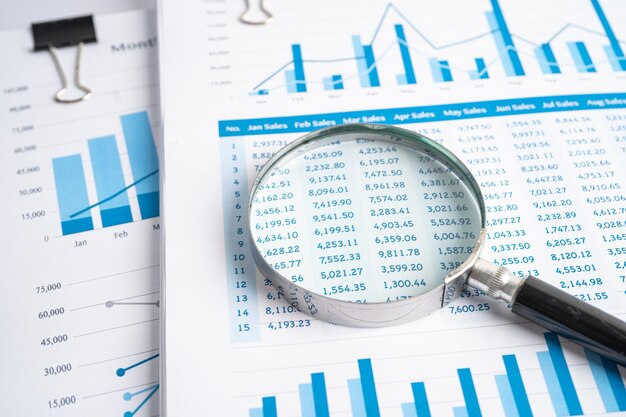 Magnifying glass on charts graphs paper. financial development,
banking account, statistics, investment analytic research data
economy, stock exchange trading, business office company meeting
concept.