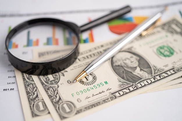 Magnifying glass on charts graphs paper Financial development