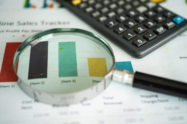 Magnifying glass on charts graphs paper