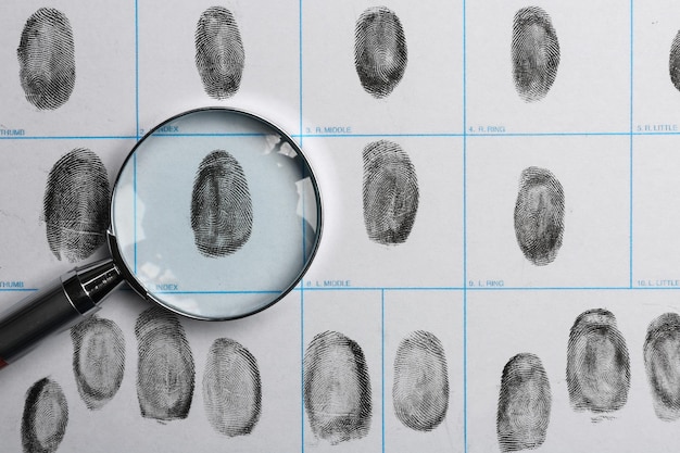 Foto lente d'ingrandimento e vista dall'alto della carta delle impronte digitali criminali