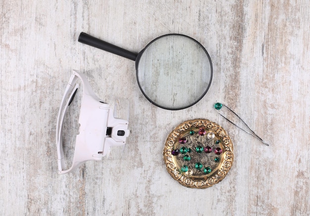 magnifying glass and emeralds on the table