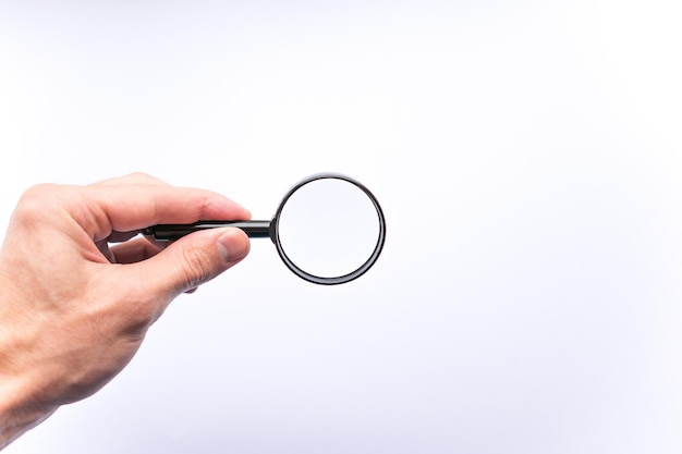 Magnifying glass in hand on white background concept of search