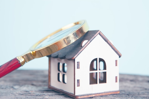 A magnifying glass and a house on the table