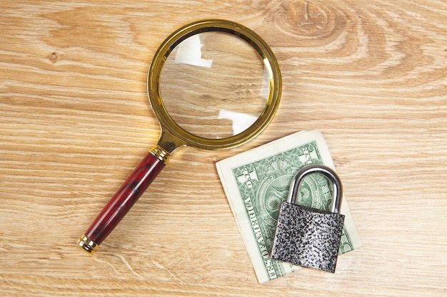 Magnifying glass, lock and money on the table