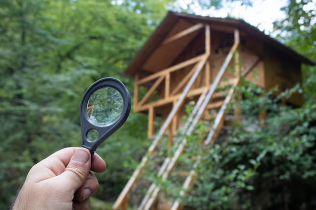 Magnifying glass looking at a cabin in the woods