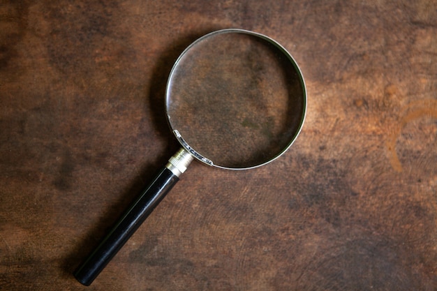 Photo a magnifying glass on an old rusty piece of iron