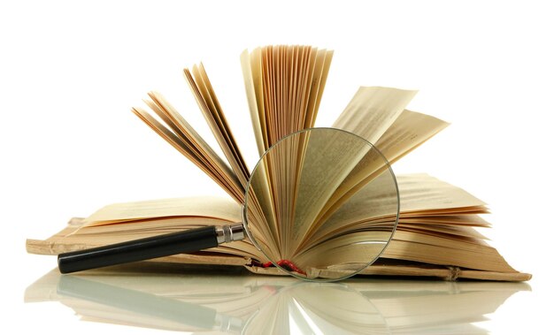 Увеличительное стекло и открытая книга, изолированные на белом фоне