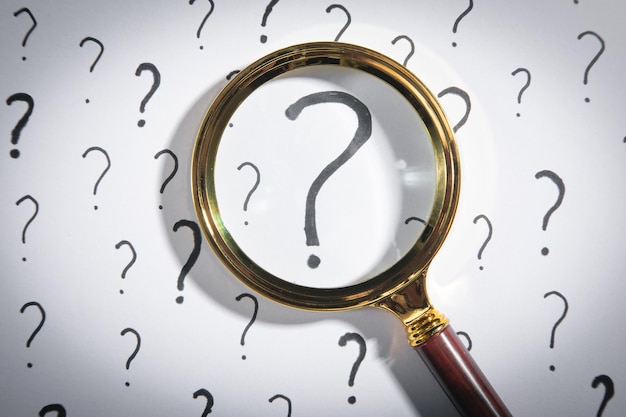 Magnifying glass and question mark on white background